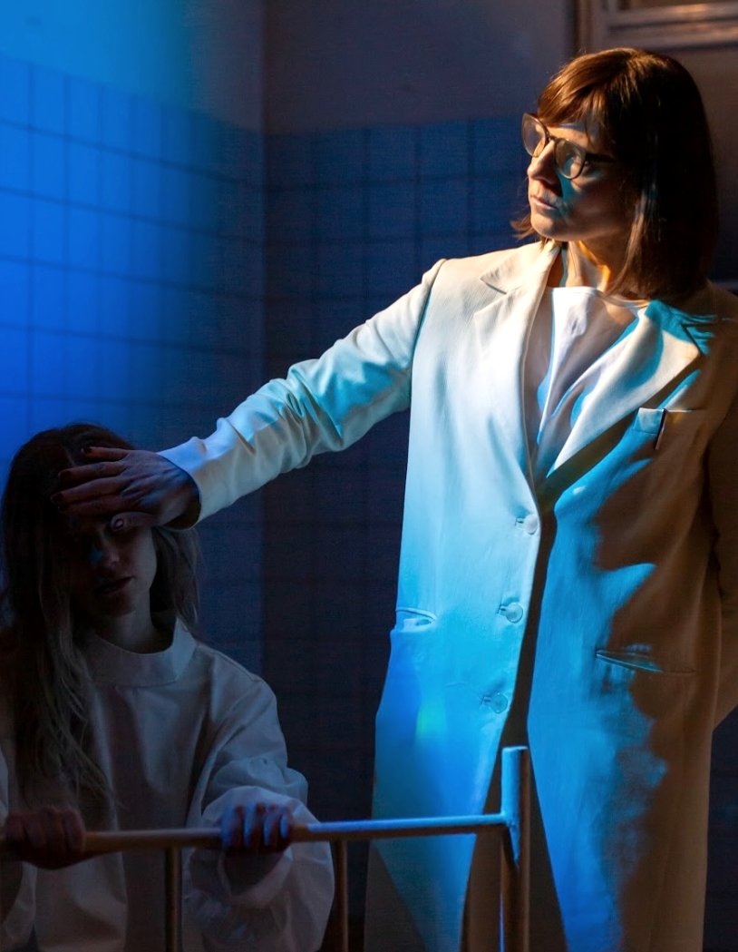 A hand on a forehead, blue-lit